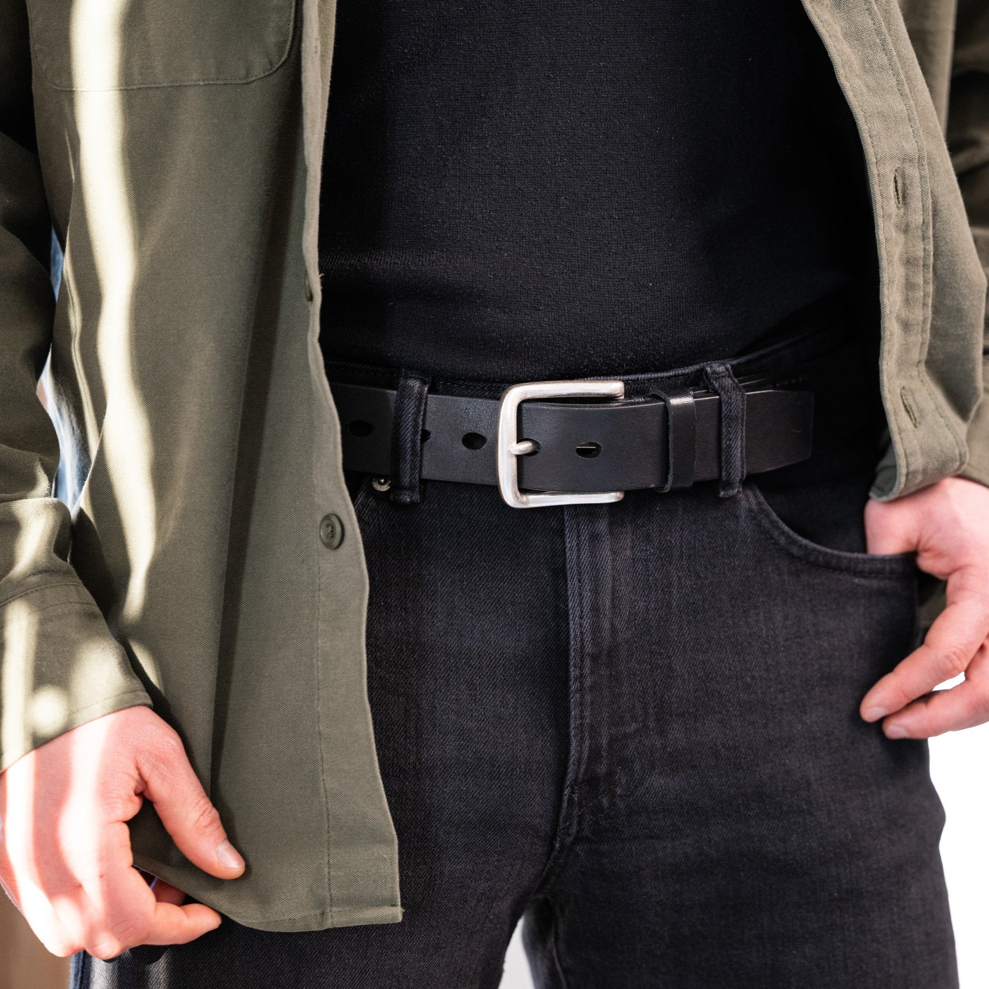 Mann mit dunkler Jeans und khaki Hemd, dazu ein dicker Ochsenledergürtel in schwarz, 4cm breit