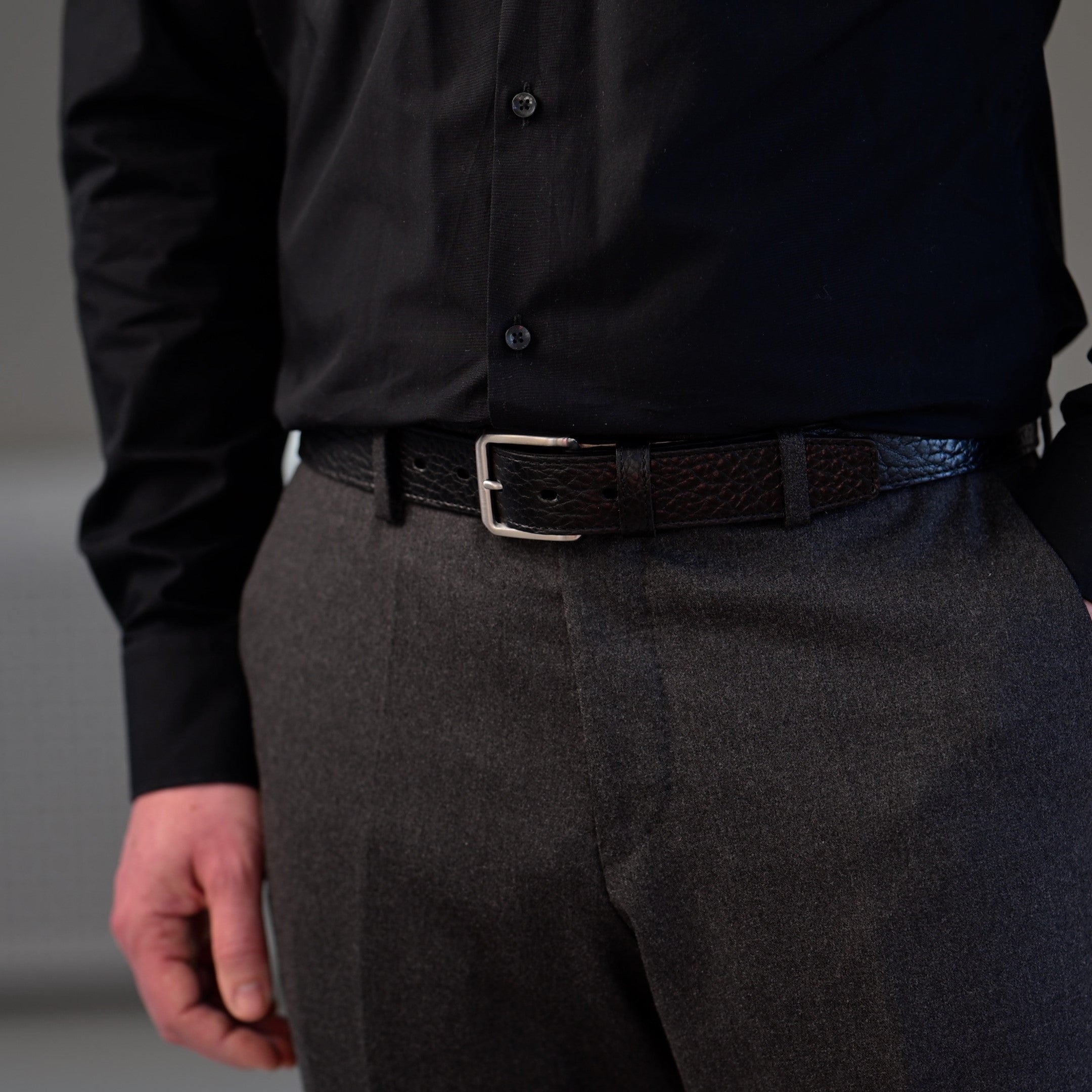 Mann mit grauer Wollhose und schwarzem Ledergürtel aus Bisonleder
